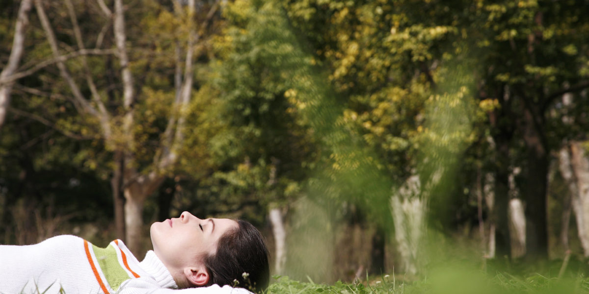 girl in grass relaxing investing in yourself