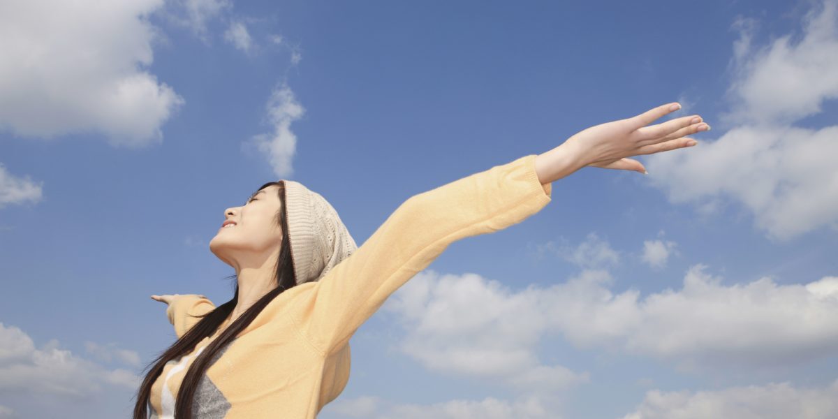 woman spreading her arms by sky to build confidence