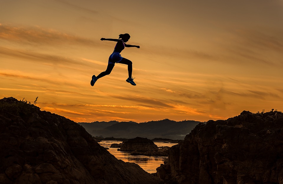 Woman jumping over mountains and lessons on Impostor Syndrome